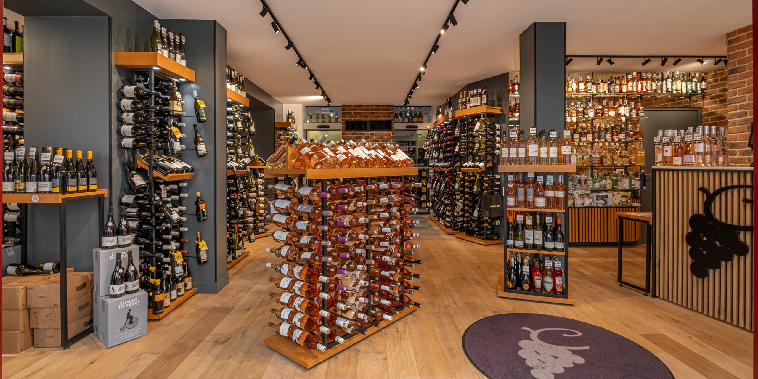 Intérieur d’une cave CAVAVIN avec rayonnages de bouteilles et espace de vente