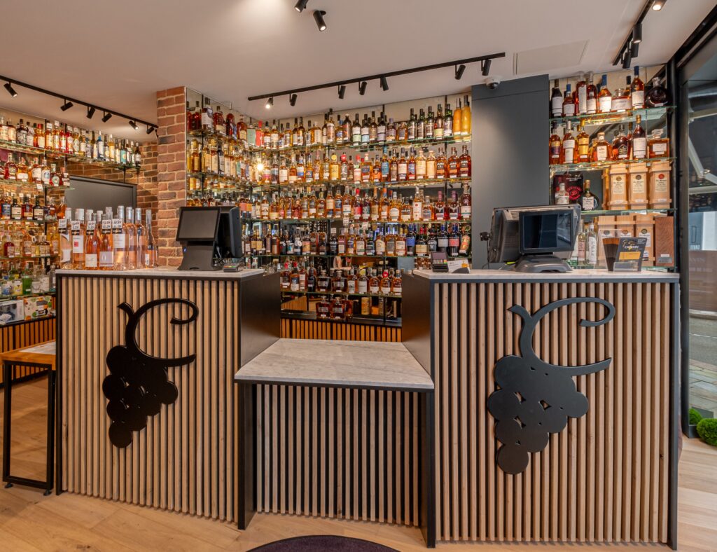 Intérieur d’une cave CAVAVIN avec espace de vente et rayonnages de bouteilles